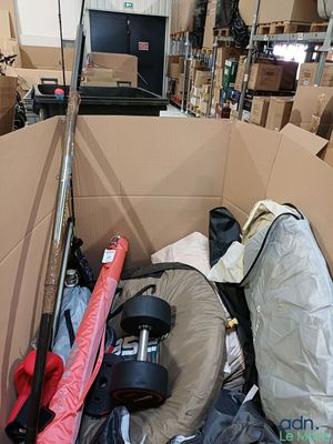 a cardboard box filled with many items in a warehouse