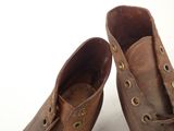 a pair of brown shoes that are on a white surface