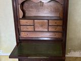 a wooden dresser with a marble top in the corner of a room