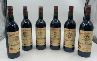 six bouteilles de vin rouge alignées sur une table