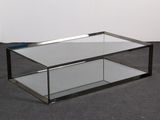 a glass coffee table with a metal frame on it
