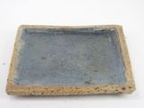 a blue and brown square dish on a white surface