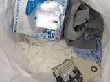 a white bag filled with clothes and a box of water