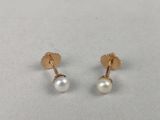 a pair of pearl earrings on a white surface