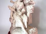 statue of a woman sitting on a rock with a man holding a child
