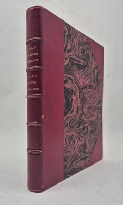 un vieux livre à la couverture rouge posé sur une table blanche