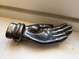 a metal hand that is sitting on a window sill