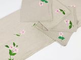 three placemats with pink flowers on them on a white table