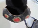 un sac à main noir orné d'un motif de rose rouge