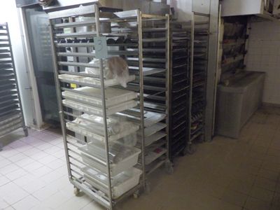 de nombreux plateaux de nourriture posés sur une étagère métallique dans une cuisine