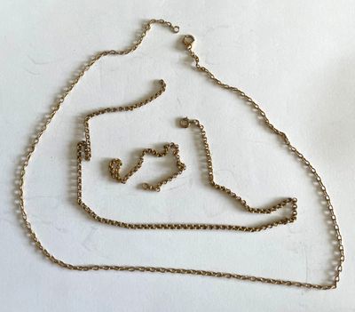 une chaîne en or ornée d'un cœur, posée sur un fond blanc