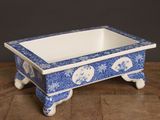 un petit bol bleu et blanc posé sur une table en bois