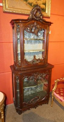 un meuble en bois avec une porte en verre dans le coin d'une pièce