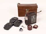 un sac en cuir marron contenant un appareil photo et quelques autres objets
