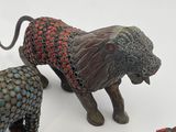 four figurines of a lion, a lion, and a giraffe on a white surface