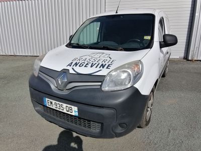 une camionnette blanche garée devant un immeuble sur lequel est accrochée une pancarte