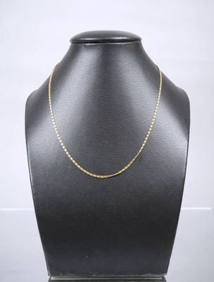 a black mannequin with a gold chain on it