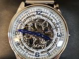 a silver watch with a blue second hand sitting on a black case