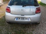 a silver car that is parked in a gravel lot