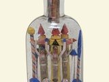 a glass bottle with a miniature castle inside of it