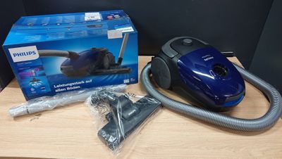 the blue vacuum is sitting on the table next to the box
