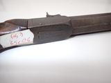 an old gun with a tag on it sitting on a table
