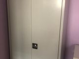 une armoire blanche avec un tiroir en dessous, dans une pièce violette