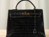 a close up of a black handbag on a wooden table