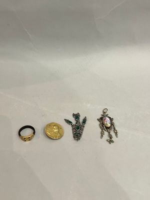 three rings and a ring with a gold coin on a white surface