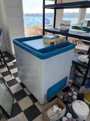 a blue and white cooler sitting on a black and white checkered floor