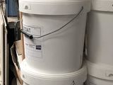 several white buckets stacked on top of each other in a warehouse