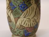 a vase with a bird design on it sitting on a table