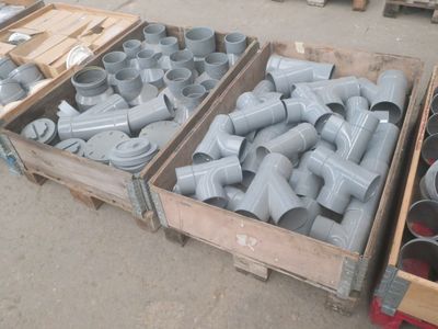des cartons contenant des raccords de tuyauterie de différentes tailles et formes dans un entrepôt