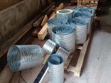 a pile of metal pipes sitting on a pallet in a warehouse