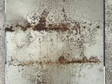 rust on a metal surface with a blue tape around it