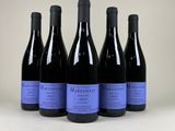 six bouteilles de vin sont alignées sur une surface blanche