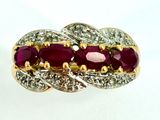 an image of a gold and ruby ring with diamonds on a white background
