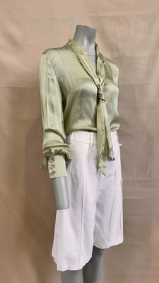 a mannequin wearing a green shirt and white skirt
