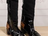 pair of black and brown boots sitting on top of a wooden table