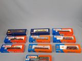 six boîtes contenant des trains miniatures, posées sur une surface blanche