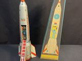 two toy rockets sit next to each other on a table
