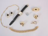 an assortment of gold and silver jewelry including a pen, bracelet, and ring