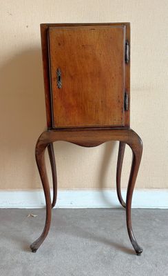 un petit meuble en bois posé sur une petite table