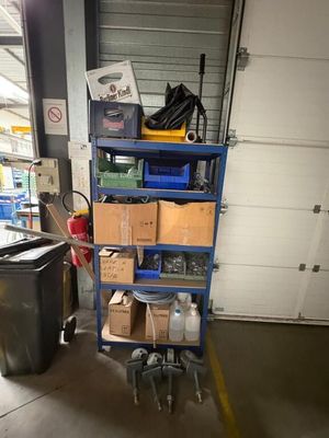 un chariot bleu chargé de cartons dans un garage