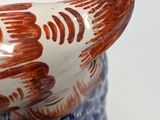 a bird that is sitting on top of a blue and white vase