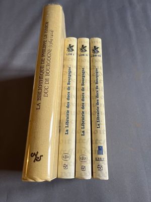 trois livres sont empilés sur une table