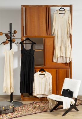 une photo d'un salon avec des vêtements suspendus à un portant