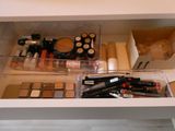 a drawer full of cosmetics and makeup products on the counter