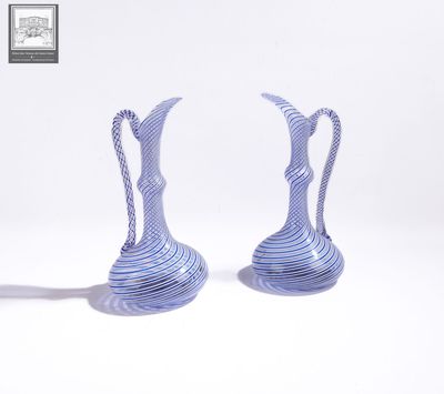 une paire de vases rayés bleus et blancs posés sur une surface blanche