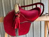 a red saddle with a tassel hanging from it